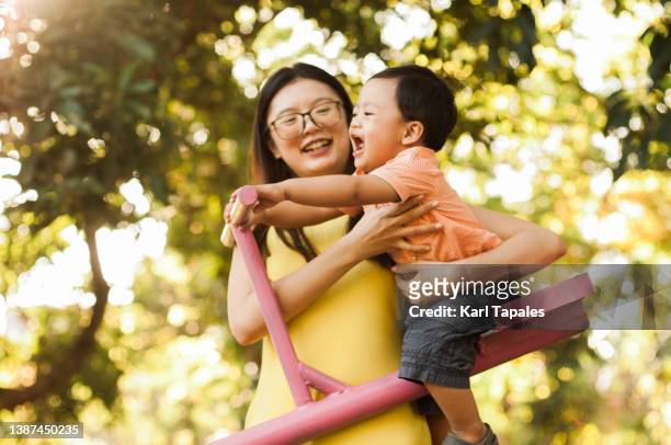 southeast asian mother and son playing in the public park - philippines family celebration stock pictures, royalty-free photos & images
