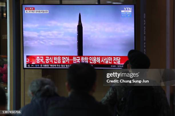 People watch a TV at the Seoul Railway Station showing a file image of a North Korean missile launch on March 24, 2022 in Seoul, South Korea. North...