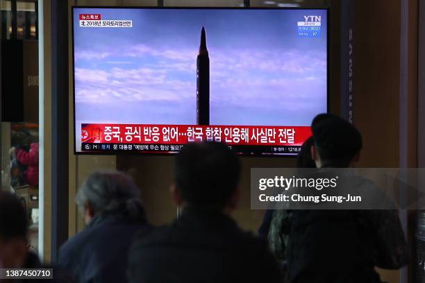 People watch a TV at the Seoul Railway Station showing a file image of a North Korean missile launch on March 24, 2022 in Seoul, South Korea. North...