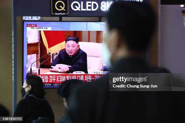 People watch a TV at the Seoul Railway Station showing a file image of preparations for a North Korean missile launch on March 24, 2022 in Seoul,...