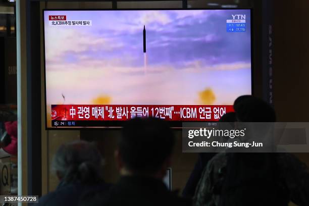 People watch a TV at the Seoul Railway Station showing a file image of a North Korean missile launch on March 24, 2022 in Seoul, South Korea. North...