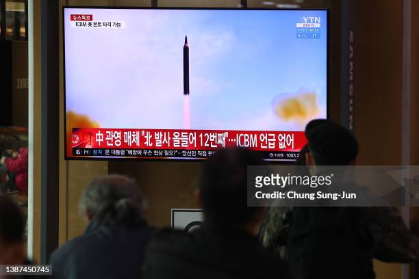 People watch a TV at the Seoul Railway Station showing a file image of a North Korean missile launch on March 24, 2022 in Seoul, South Korea. North...