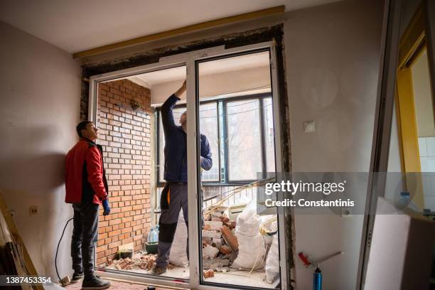 professional workers installing the window frame - raamkozijn stockfoto's en -beelden