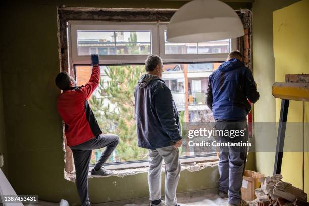 rear view of workers installing the window frame - window frame stock pictures, royalty-free photos & images