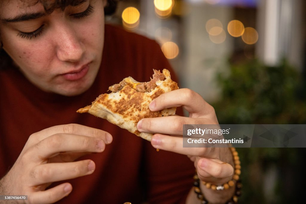 Teenager Eating a Wrap Sandwich with Hands