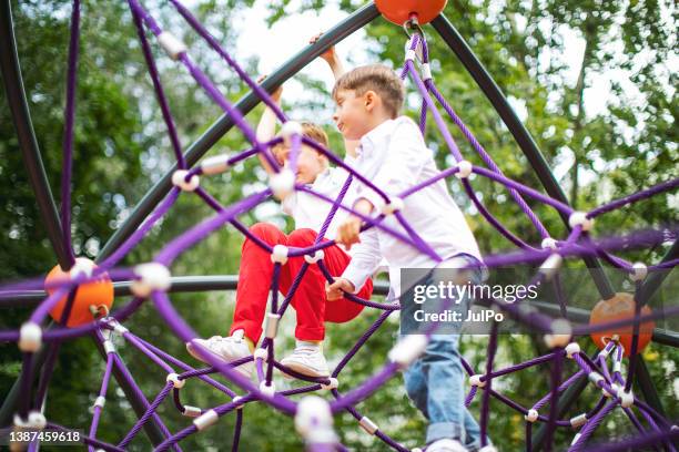 preschool boys enjoying at playground - climbing frame stock pictures, royalty-free photos & images