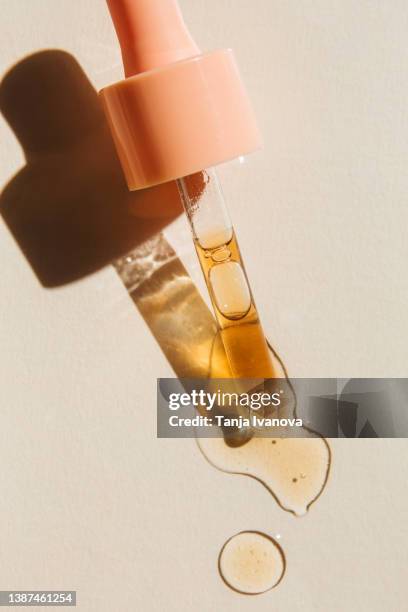 liquid gel or serum drop with pipette on beige background. beauty product with peptides, ceramides, hyaluron gel, polyglutamic acid. multitasking beauty. flat lay, top view. - pipette stock-fotos und bilder