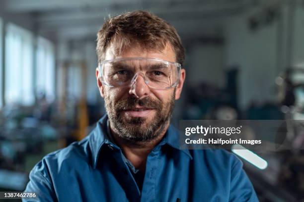 portrait of smiling mechanic standing in garage workshop with professional equipment - repairman stock pictures, royalty-free photos & images