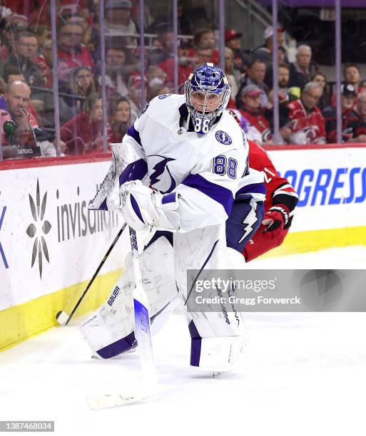 Andrei Vasilevskiy of the Tampa Bay Lightning plays the puck along the boards behind the net during an NHL game against the Carolina Hurricanes on...