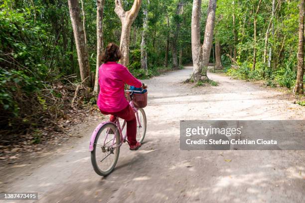 woman on bike exploring coba site, mexico - coba stock pictures, royalty-free photos & images