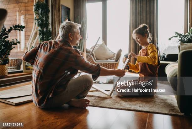 father and teen daughter assembling new furniture in the renovated apartment - building shelves stock pictures, royalty-free photos & images
