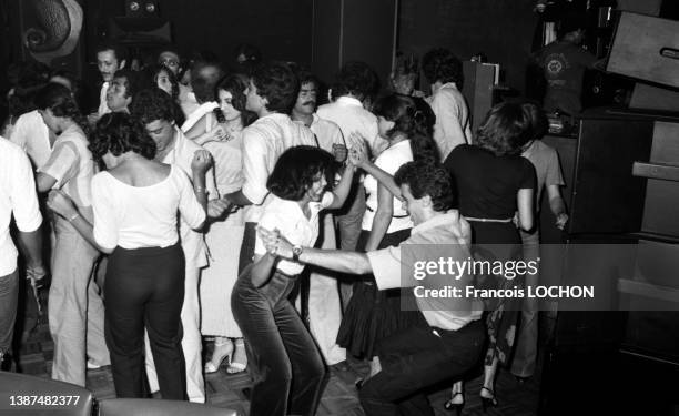 Jeunes femmes et jeunes hommes dansant et s'amusant dans une boite de nuit en juillet 1978 à Beyrouth.