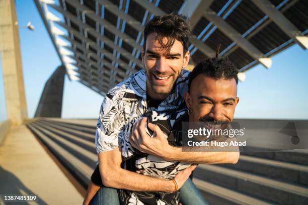 gay couple smiling looking at camera. - hispanic gay man stock pictures, royalty-free photos & images