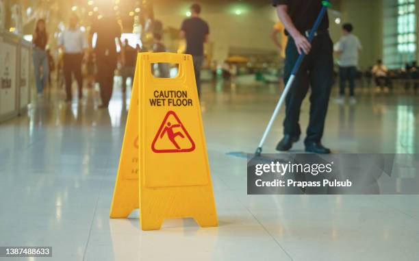 yellow wet floor warning sign on the floor - wetter imagens e fotografias de stock