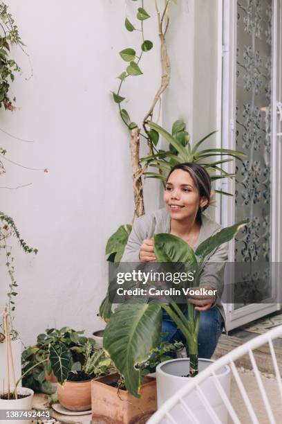 happily brown skin woman attending plants on her house - human skin 個照片及圖片檔