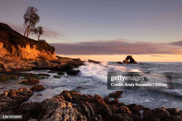 rugged coast,scenic view of sea against sky during sunset,corona del mar,united states,usa - newport beach california stockfoto's en -beelden
