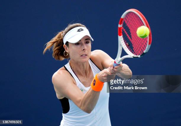 Alize Cornet of France returns a shot to Alison Riske of the United States during the 2022 Miami Open presented by Itaú at Hard Rock Stadium on March...