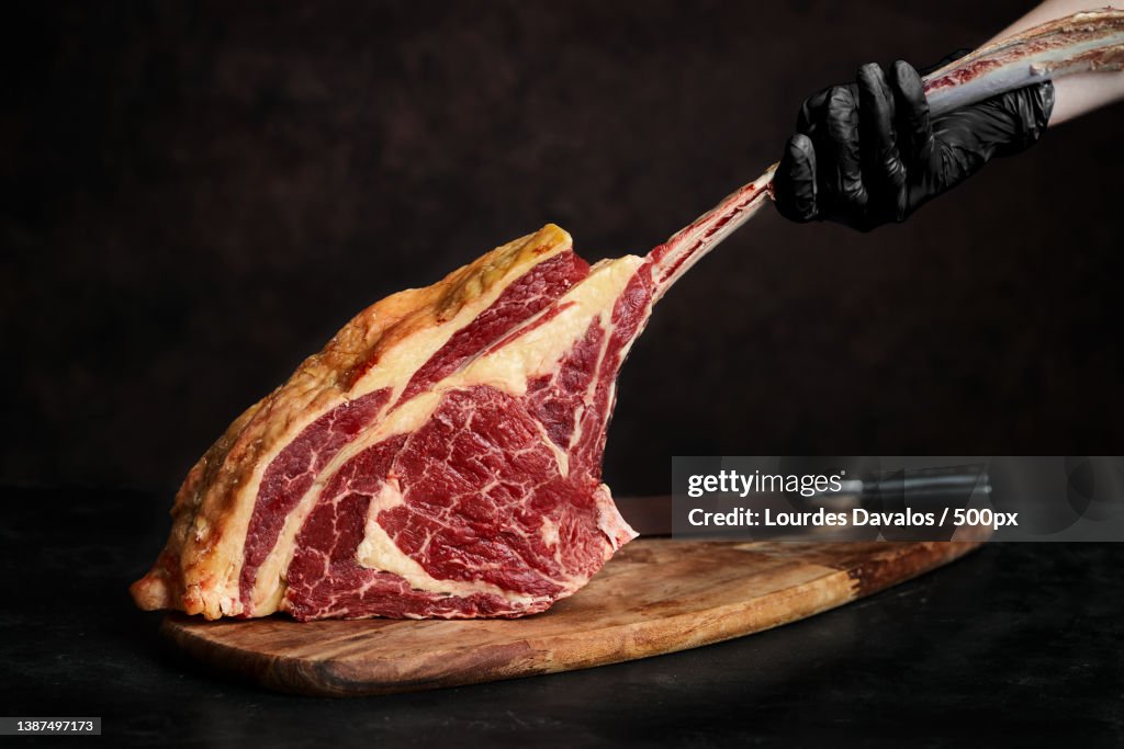 Close-up of meat on cutting board over black background