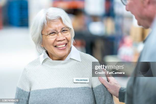 senior volunteer at a food bank - name tag stock pictures, royalty-free photos & images
