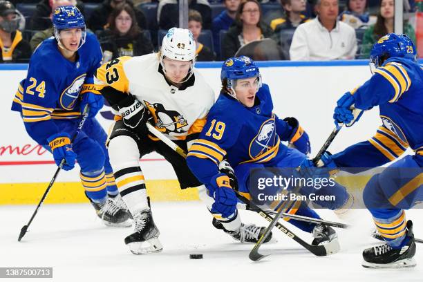 Danton Heinen of the Pittsburgh Penguins and Peyton Krebs of the Buffalo Sabres battle for the puck during an NHL game on March 23, 2022 at KeyBank...