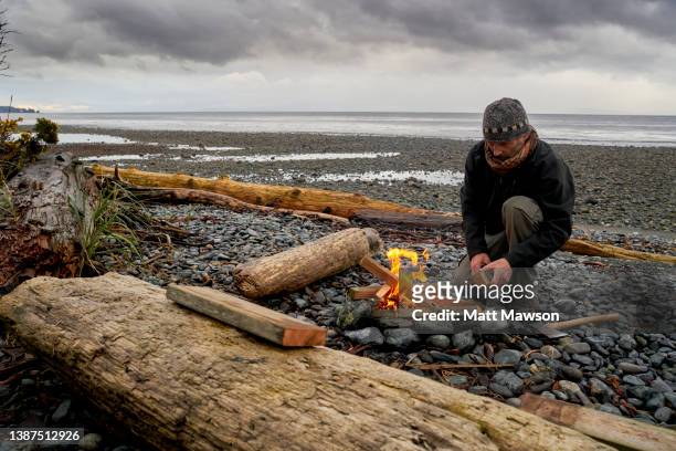 a senior man and his campfire vancouver island bc canada - carmanah walbran provincial park stockfoto's en -beelden