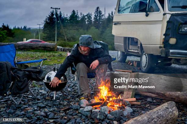 a senior man and his campfire vancouver island bc canada - carmanah walbran provincial park stock pictures, royalty-free photos & images
