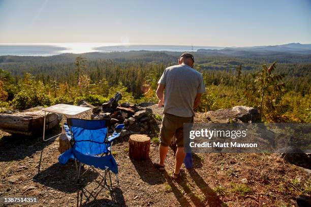 a senior man and his campfire vancouver island bc canada - carmanah walbran provincial park stockfoto's en -beelden