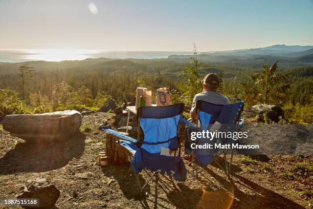 a senior man and his campfire vancouver island bc canada - carmanah walbran provincial park stockfoto's en -beelden