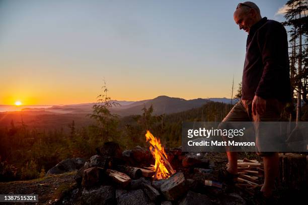 a senior man and his campfire vancouver island bc canada - steilanstieg stock-fotos und bilder