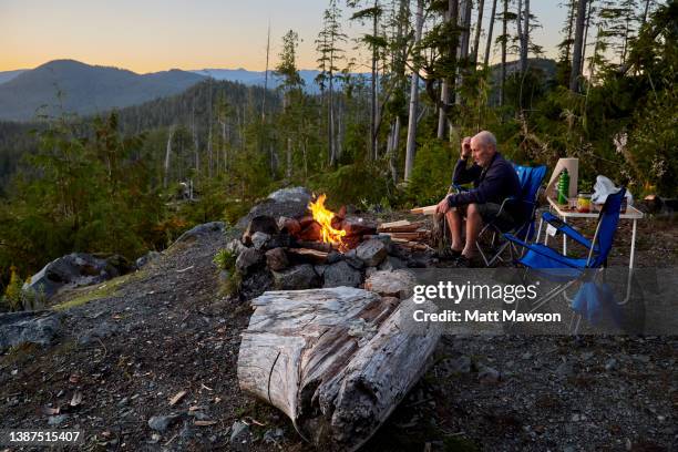 a senior man and his campfire vancouver island bc canada - carmanah walbran provincial park stock pictures, royalty-free photos & images