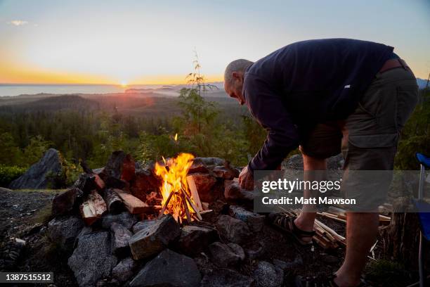 a senior man and his campfire vancouver island bc canada - carmanah walbran provincial park stockfoto's en -beelden