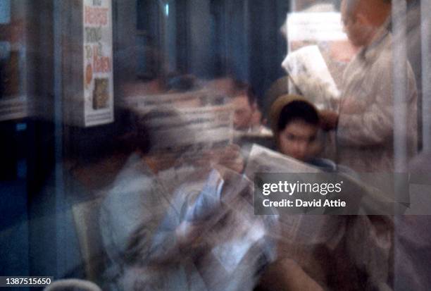 Blurred motion image of passengers on the New York City subway with vintage ads in the background in January 1959 in New York City, New York.