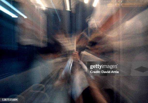 Blurred motion image of passengers on the New York City subway with vintage ads in the background in January 1959 in New York City, New York.
