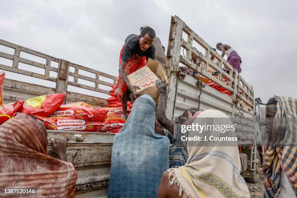 Workers from Islamic Relief - Ethiopia off load food stuffs for distribution at the Silsa IDP Camp on March 24, 2022 in Silsa, Ethiopia. The TPLF...