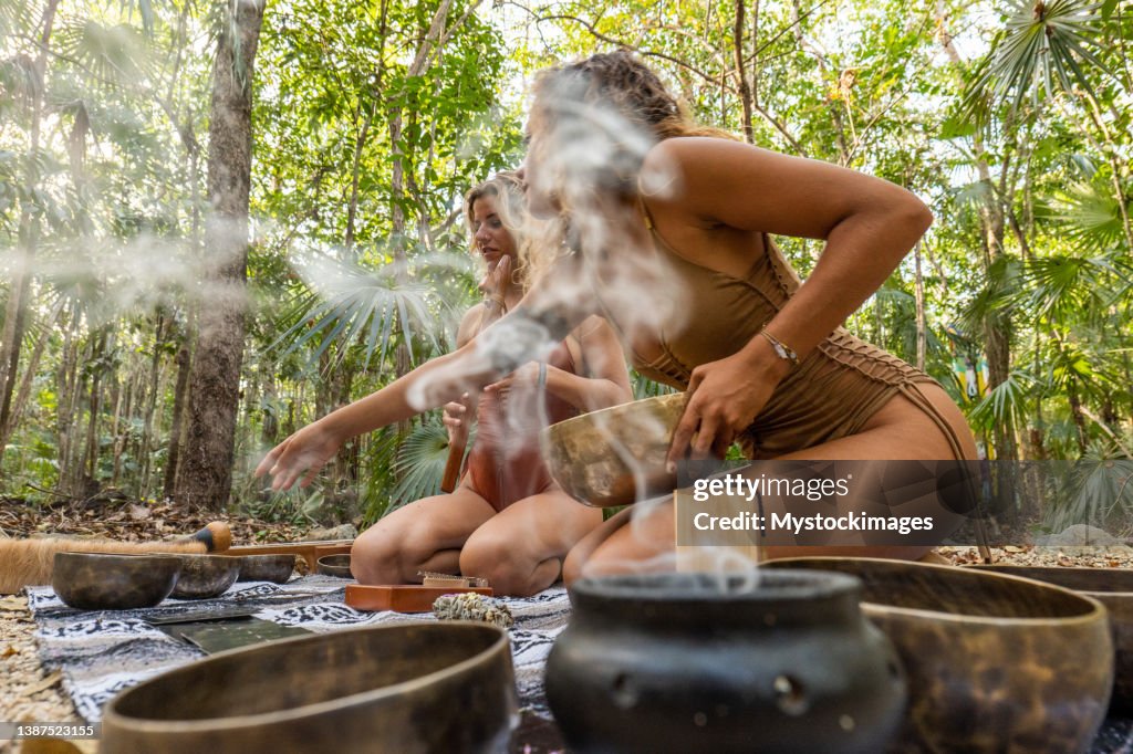 Sound healing ceremony in the rainforest, two women