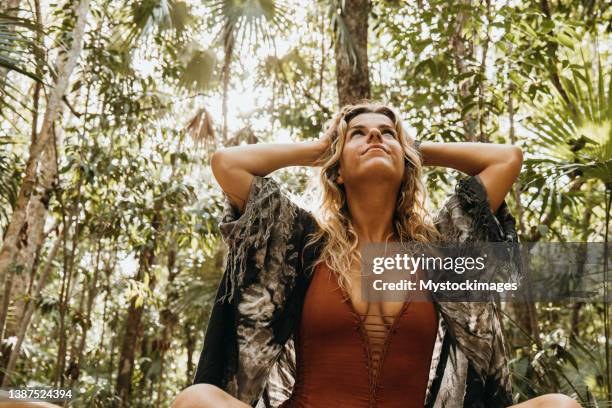 spirituelle frau im regenwald im sonnenlicht - the shamen stock-fotos und bilder