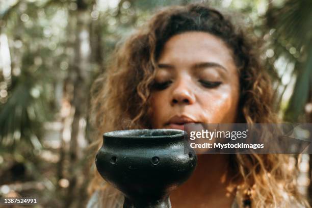 una donna multirazziale nella foresta pluviale con l'incenso tra le mani - solfato di cobalto foto e immagini stock