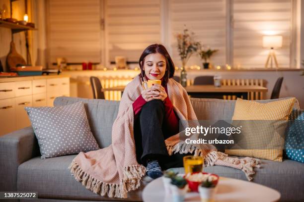 beautiful woman drinking hot tea wrapped in blanket - wrapped in a blanket stock pictures, royalty-free photos & images