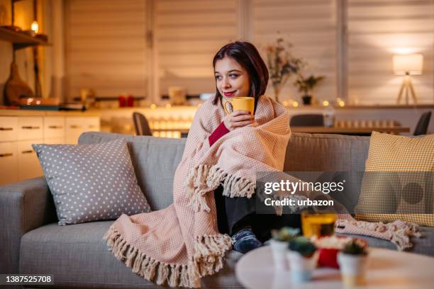 bella donna che beve tè caldo avvolto in coperta - cold temperature foto e immagini stock