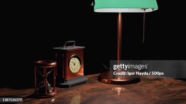 steampunk still life,close-up of illuminated lamp on table against black background - steampunk originals stock pictures, royalty-free photos & images