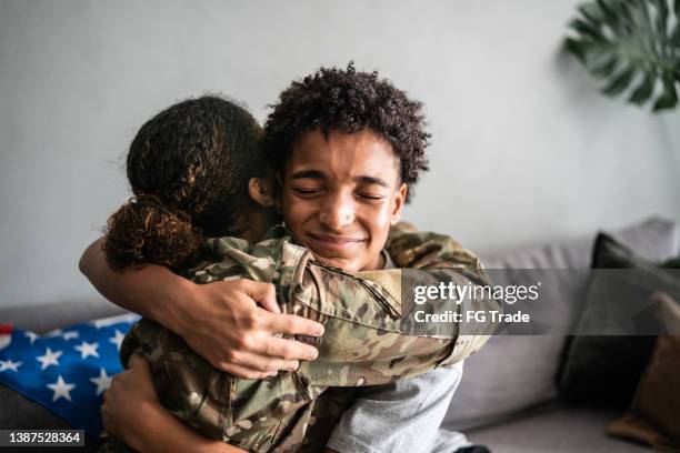 soldier mother and son hugging each other at home - amerikanska militären bildbanksfoton och bilder