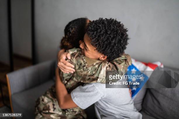 soldier mother and son hugging each other at home - boy hugs mother stock pictures, royalty-free photos & images