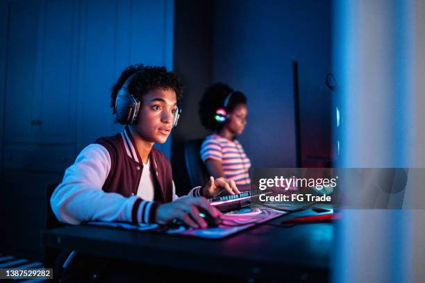 adolescent jouant sur l’ordinateur à la maison - famille jeux société photos et images de collection