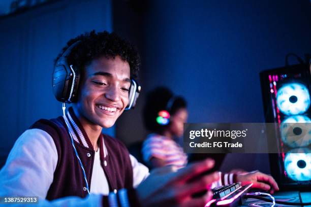 teenage boy playing mobile game at home - mobile game stock pictures, royalty-free photos & images