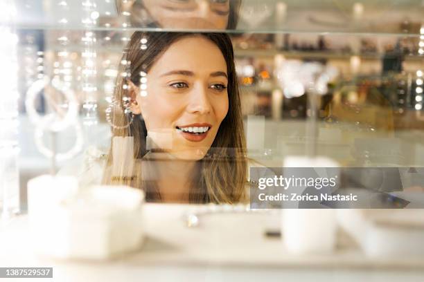 mujer mirando joyas en una tienda - jeweller fotografías e imágenes de stock