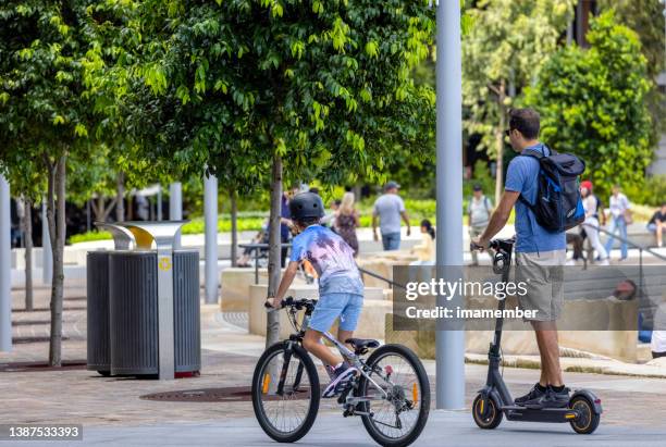 padre e hijo pequeño en bicicleta en la ciudad, fondo con espacio de copia - holiday scooter fotografías e imágenes de stock