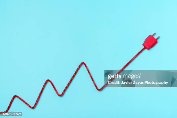 red electric power plug on blue background. increase to electricity prices concept. - electrical plug foto e immagini stock