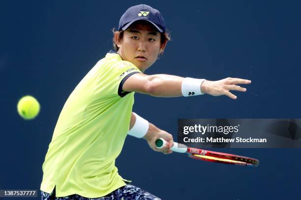 Yoshihito Nishioka of Japan returns a shot to Emilo Gomez of Ecuador during the Miami Open at Hard Rock Stadium on March 24, 2022 in Miami Gardens,...