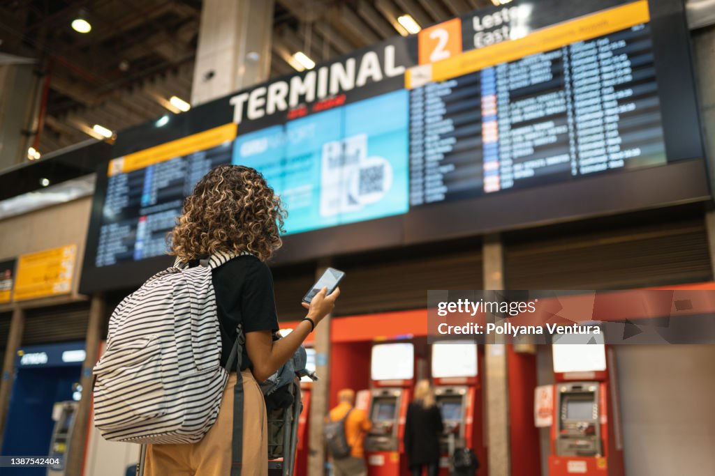 Touristen, die sich die Ankunfts- und Abreisetabelle ansehen