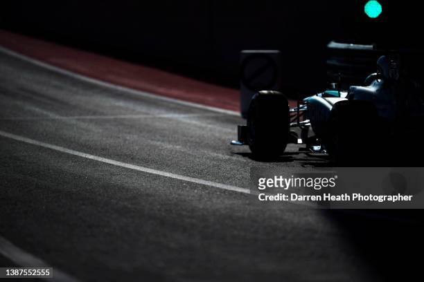 Photographed from a rear view, and in back lit light, German Mercedes-AMG Formula One racing team racing driver Nico Rosberg driving his F1 W04...